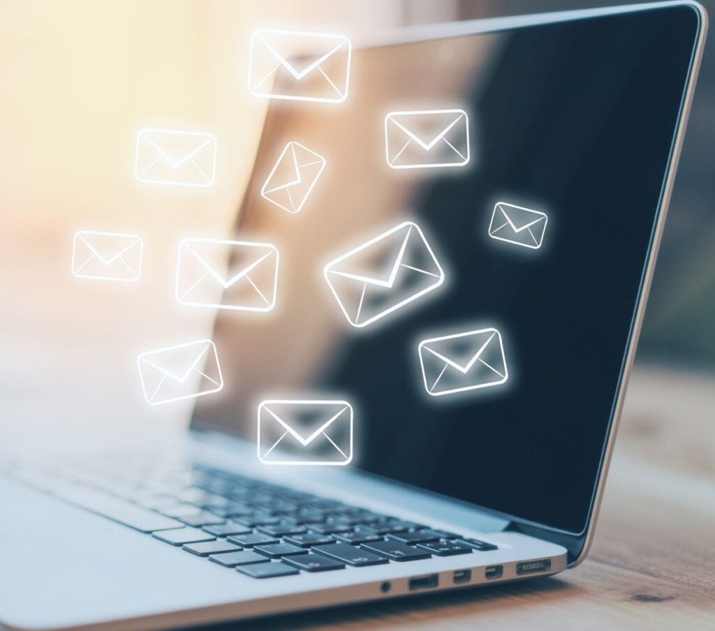 The image shows a laptop with glowing envelope icons on the screen, symbolizing incoming emails or a newsletter.