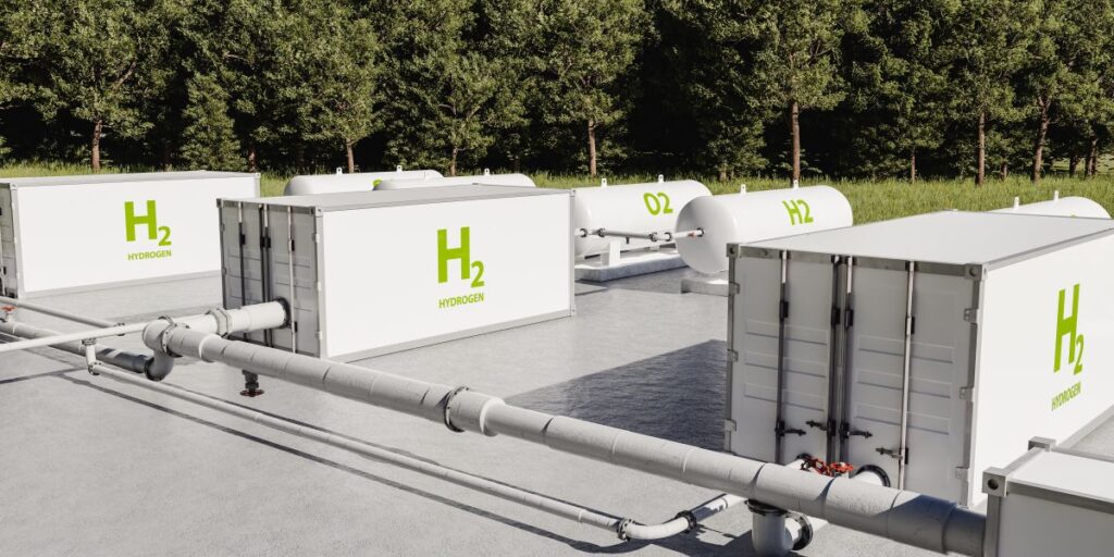 3D rendering of a hydrogen facility with storage units and pipes set beside a forest.