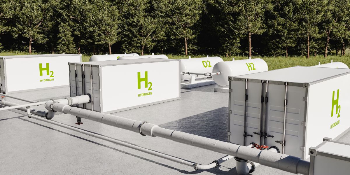 3D rendering of a hydrogen facility with storage units and pipes set beside a forest.